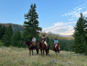 Blackwater Creek Ranch with the riders on horses positioned for the photographer to take the shot.