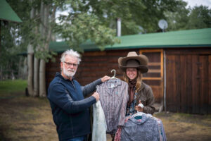 The Photographer and wardrobe stylist choosing from a selection of western shirts and cowboy hats for subjects to wear in the photographs.